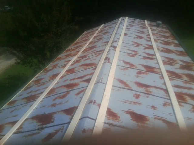 Rusted metal roof panels with new wood purlins before replacement — Storm Damage Roof Repair in Remington by Roofing Brothers