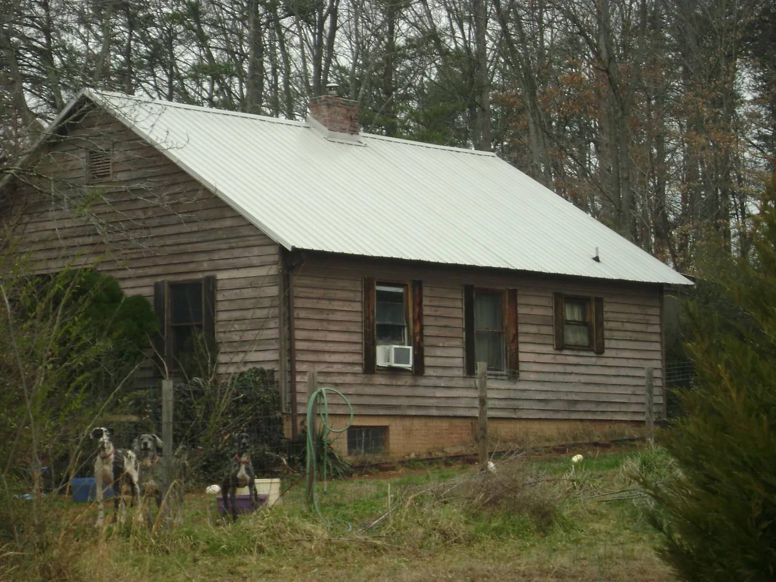 White metal roof on an old wood sided farmhouse, from a Metal Roof Installation job in Remington